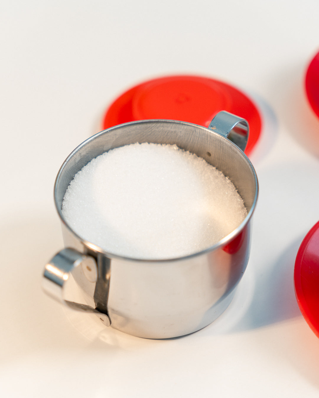 Vintage 1970s Jolly Rivadossi Italy double-walled stainless steel espresso cups with plastic red accent, saucers and sugar server. Vecino Shop
