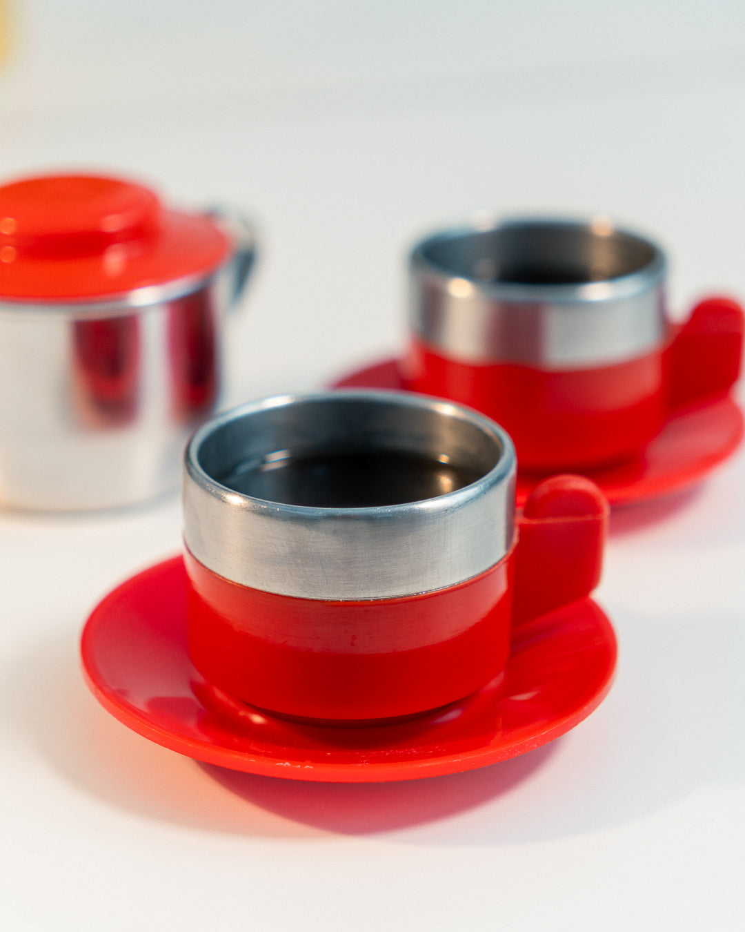 Vintage 1970s Jolly Rivadossi Italy double-walled stainless steel espresso cups with plastic red accent, saucers and sugar server. Vecino Shop