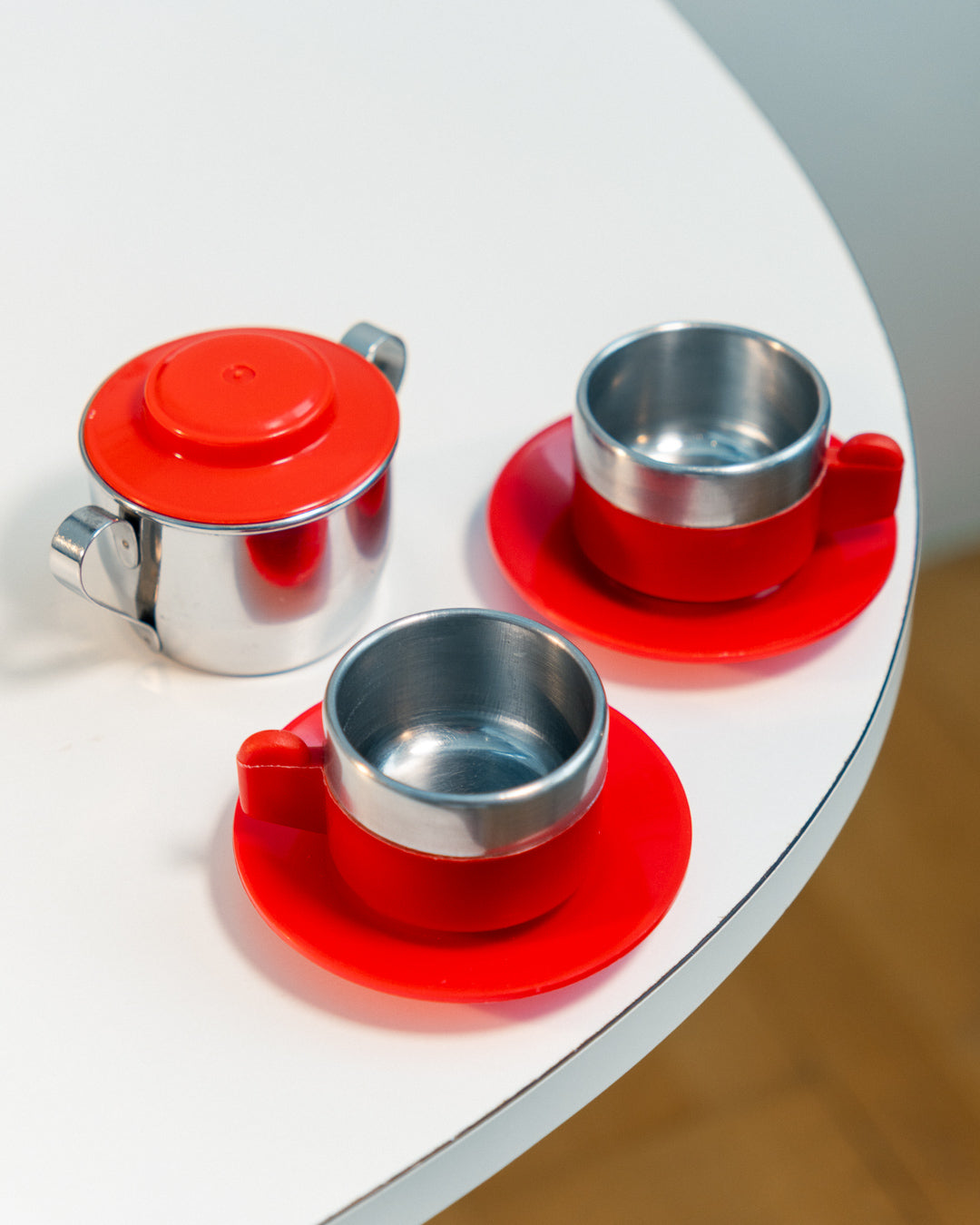 Vintage 1970s Jolly Rivadossi Italy double-walled stainless steel espresso cups with plastic red accent, saucers and sugar server. Vecino Shop