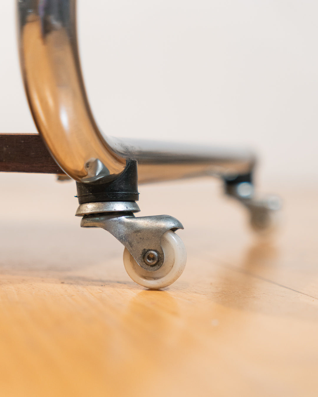 1970s chrome rolling side table with smoked glass top, wooden shelf, wheels, and magazine rack. Vecino Shop