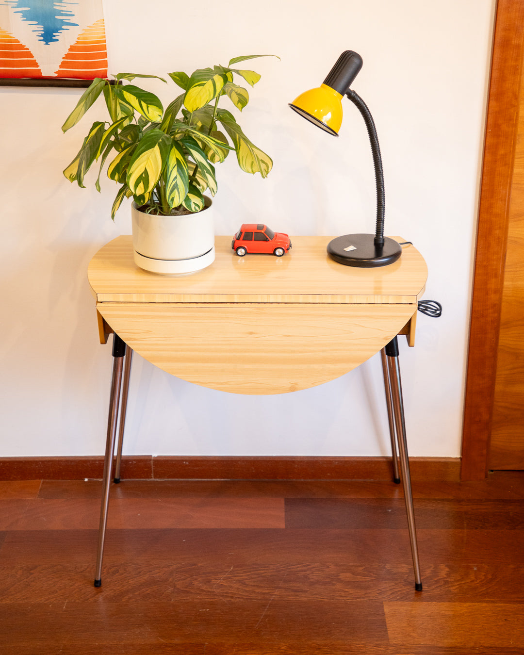 Vintage 1970s folding round table made of light wood-look formica with chrome legs and two drawers