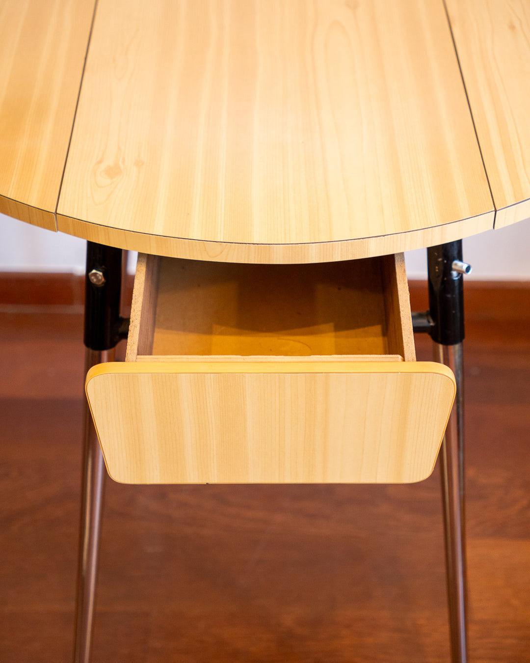 Vintage 1970s folding round table made of light wood-look formica with chrome legs and two drawers