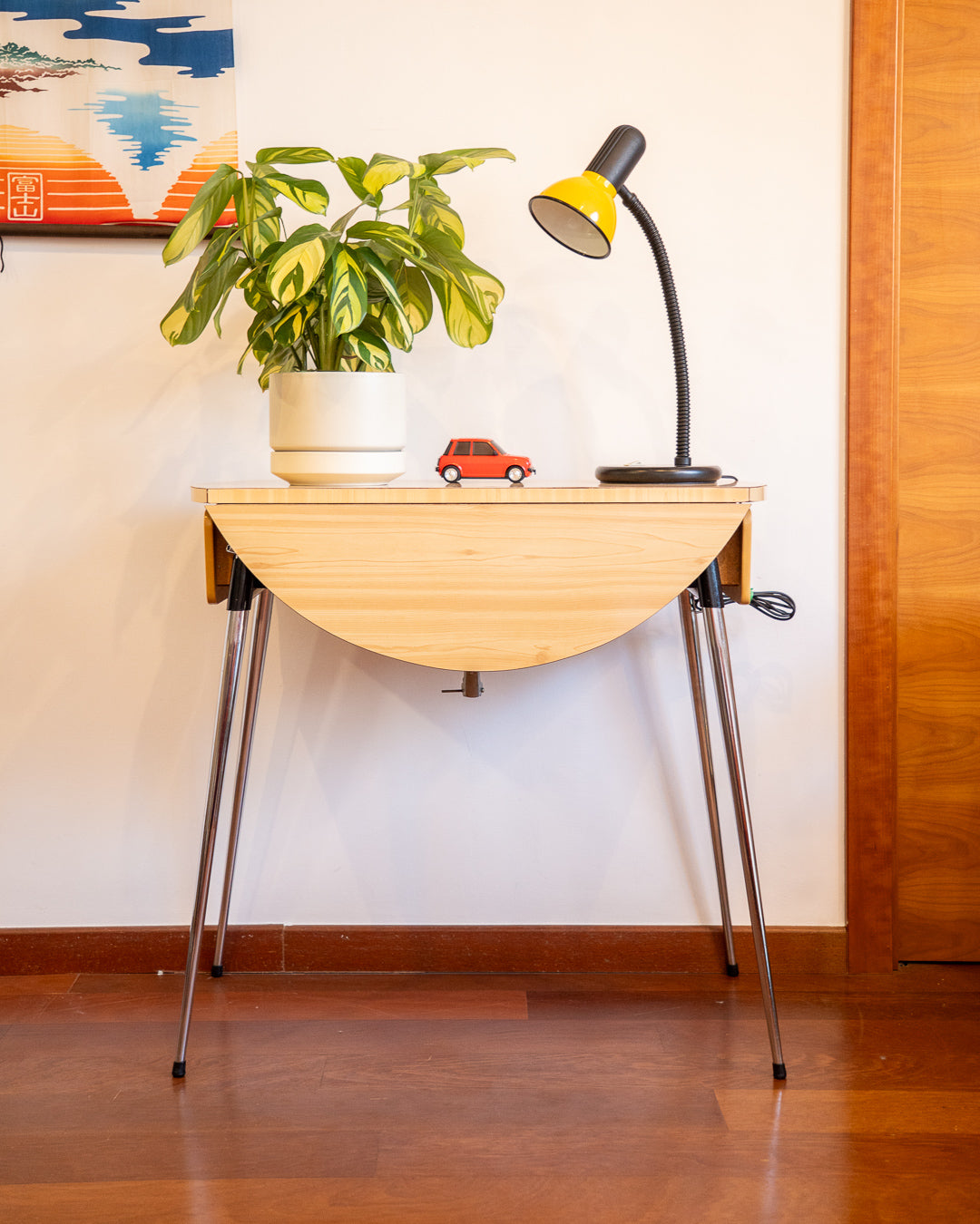 Vintage 1970s folding round table made of light wood-look formica with chrome legs and two drawers
