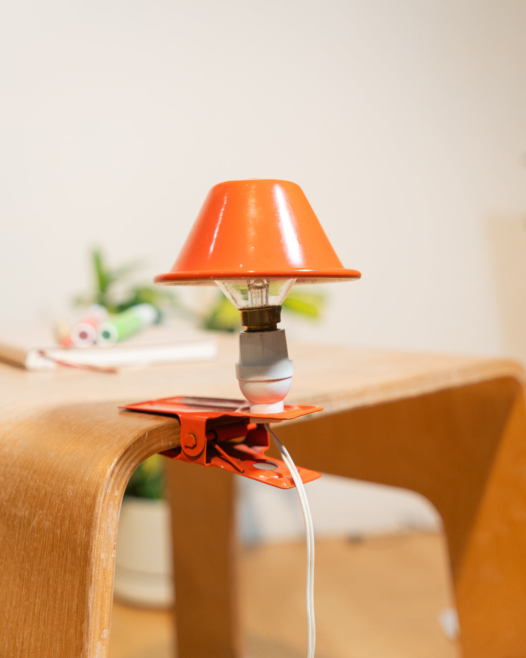 Vintage orange Luxus mushroom clip lamp from the 1970s with white housing and clamp base. Retro space age lighting piece.