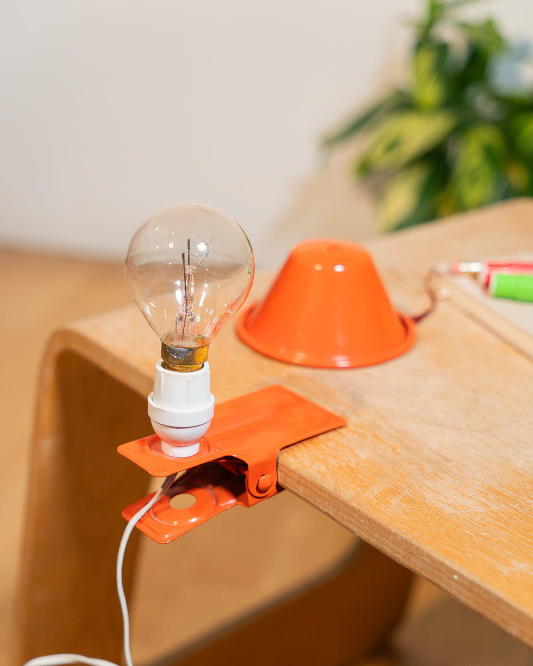 Vintage orange Luxus mushroom clip lamp from the 1970s with white housing and clamp base. Retro space age lighting piece.