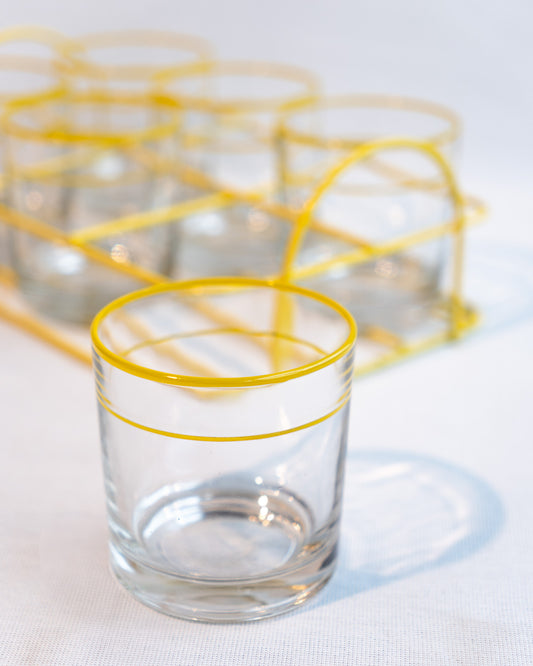Set of six vintage clear glasses with yellow stripes in a yellow metal serving rack, retro drinkware display - Vecino Shop